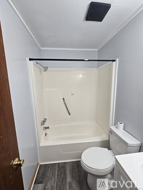 A white toilet sits next to a walk-in shower in a bathroom.