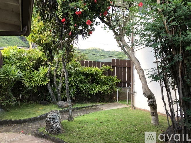A garden with a stone statue and flowering trees.