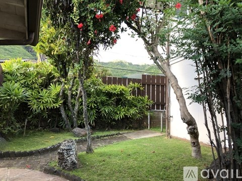 A garden with a stone statue and flowering trees.