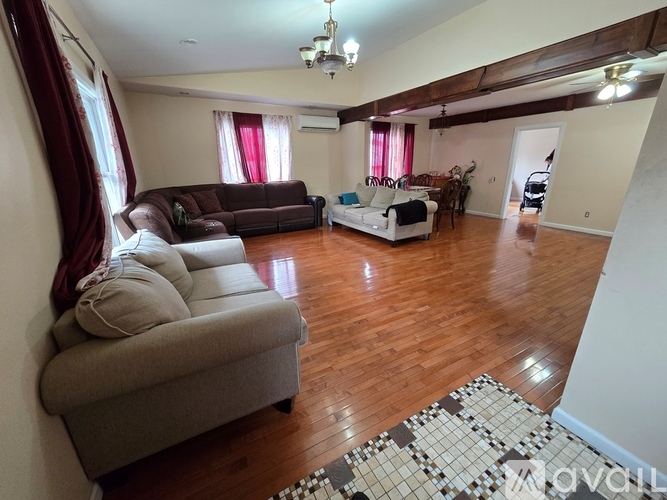 A living room with a brown couch and a white sofa.