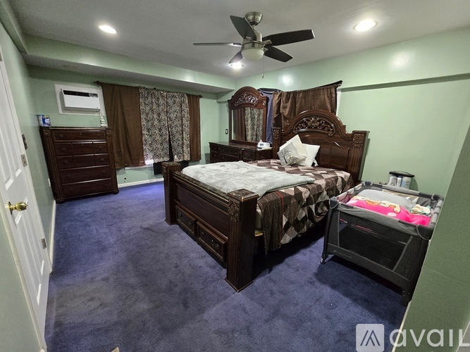 A bedroom with a large bed and a ceiling fan.