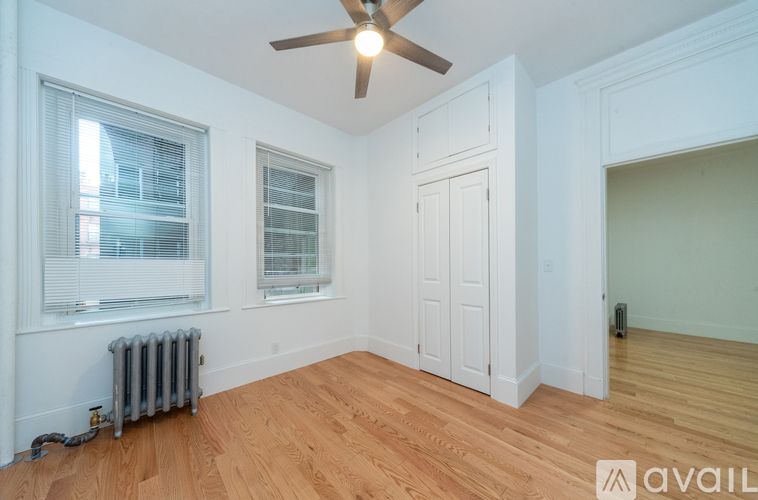 A room with a fan, a window, and a door.