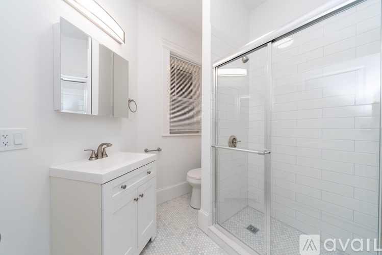 A white bathroom with a glass shower stall.