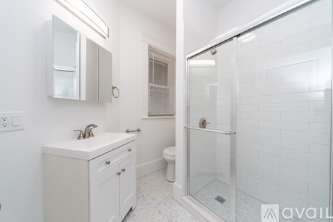 A white bathroom with a glass shower stall.
