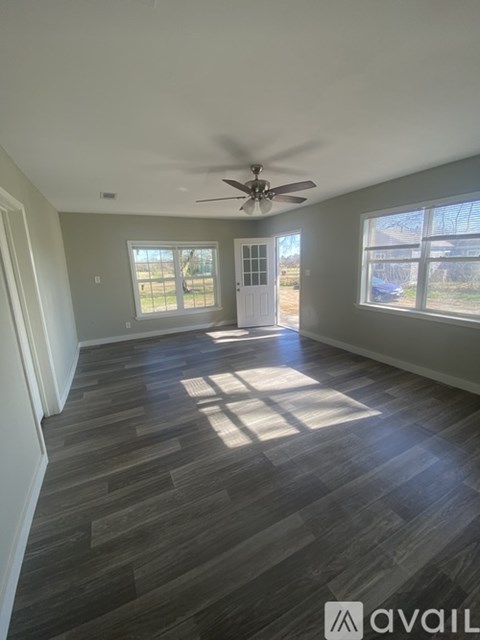A room with a large window and a wooden floor.
