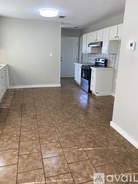 A kitchen with white appliances and cabinets.