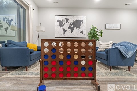 A wooden four in a row game is in the middle of a living room.