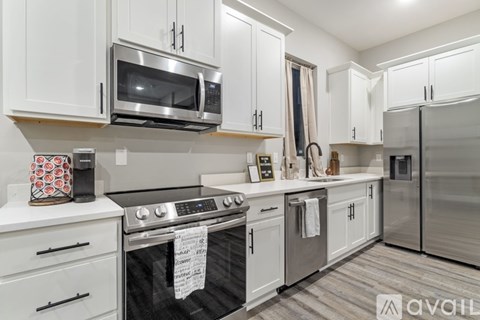 A kitchen with white cabinets and a black stove top.