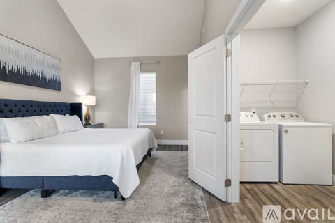 A bedroom with a large bed and a white wardrobe.