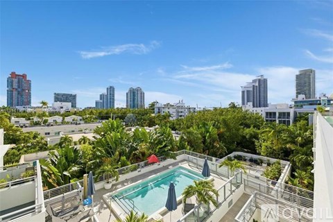 A pool on a balcony overlooks a cityscape.