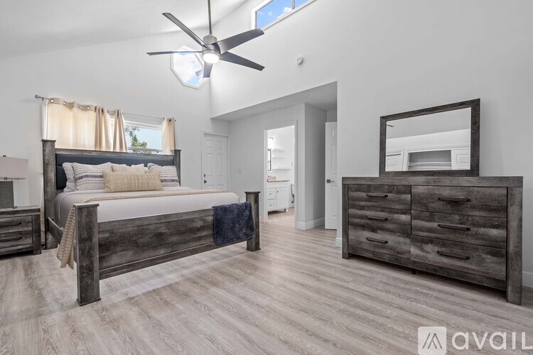 A bedroom with a large bed and a dresser.