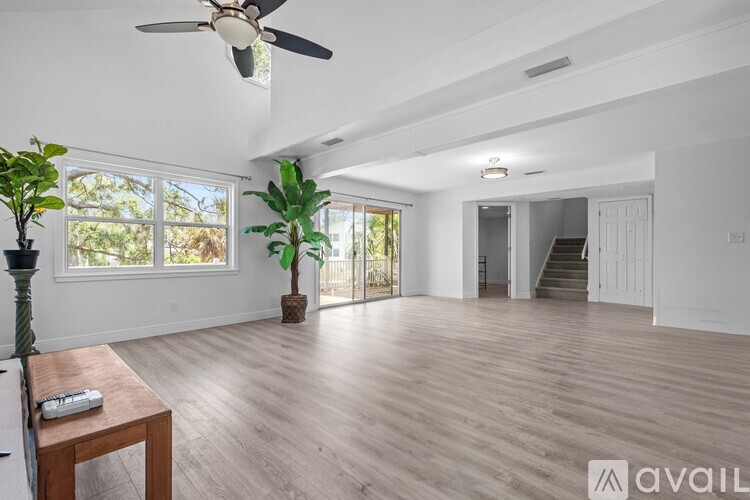 A spacious room with a ceiling fan and wooden flooring.