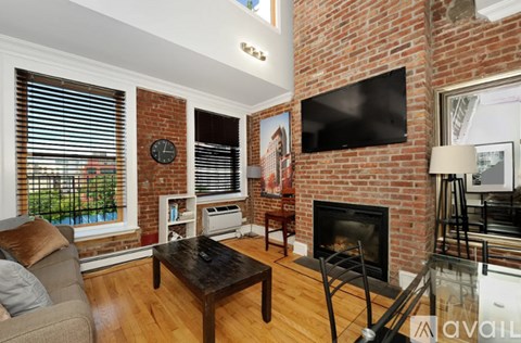 A living room with a fireplace and a flat screen TV mounted on the wall.