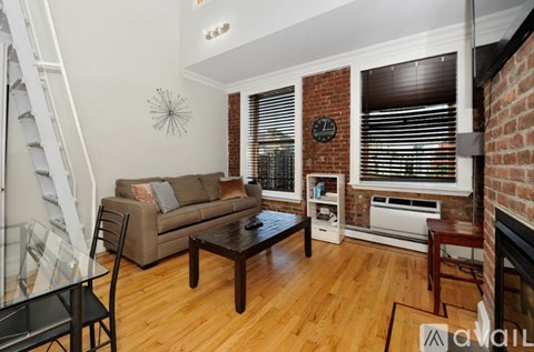 A living room with a couch, a chair, a coffee table, and a fireplace.