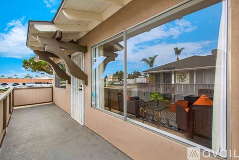 A balcony with a table and chairs overlooking a residential area.