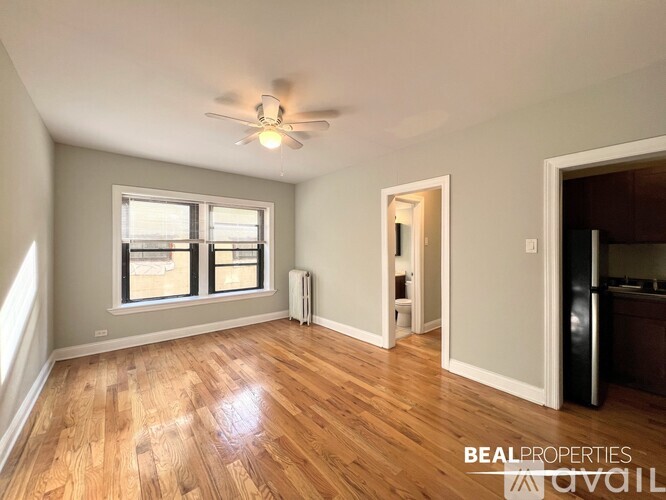 A room with wooden floors and a ceiling fan.