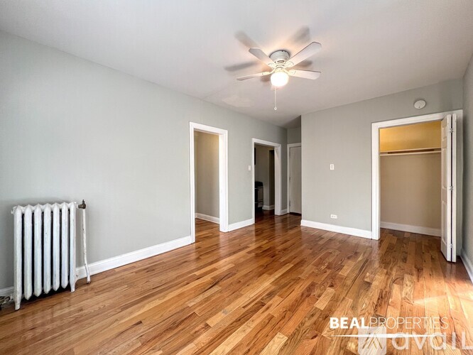 A room with a ceiling fan and wooden flooring.
