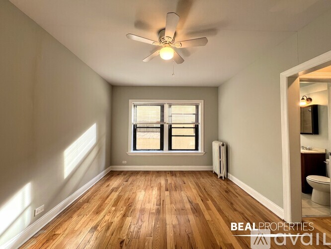 A room with a window and a fan on the ceiling.