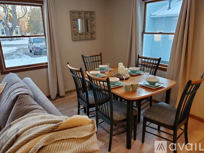 A dining room with a table set for four.