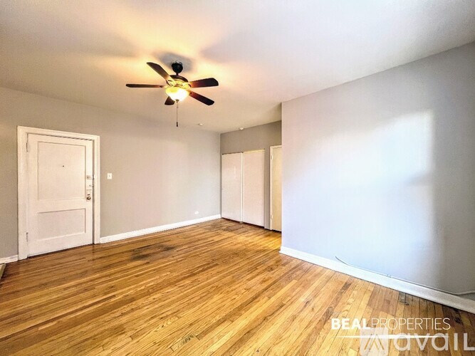A room with a ceiling fan and wooden flooring.