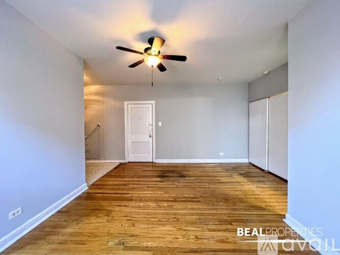 A room with a ceiling fan and wooden flooring.