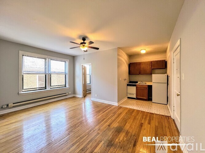 A spacious room with a ceiling fan and wooden flooring.