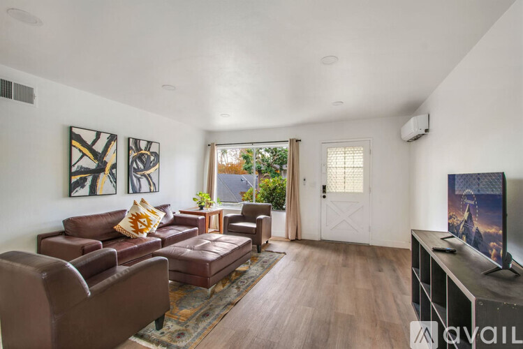 A living room with brown leather furniture and a flat screen TV.