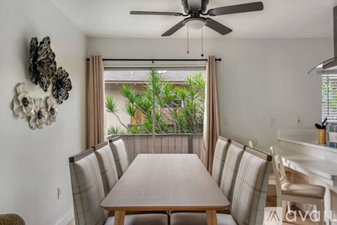 A dining room with a wooden table and chairs.