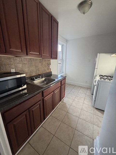 A kitchen with brown cabinets and a white dishwasher.