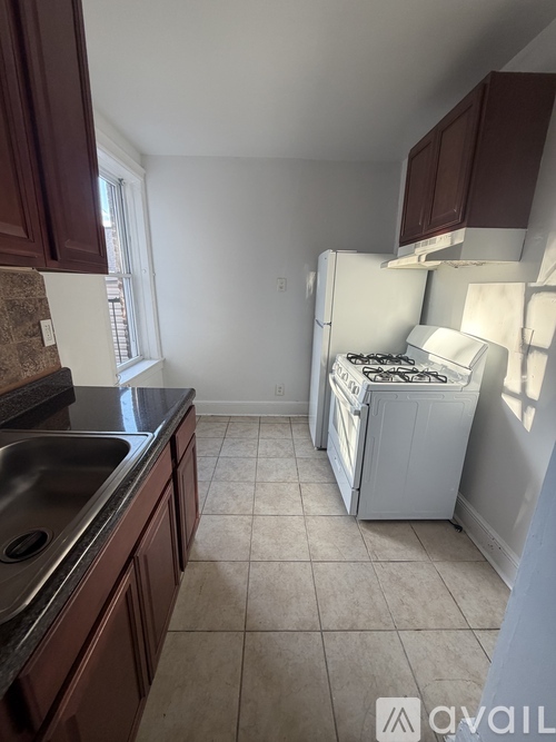 A kitchen with brown cabinets and a white fridge.
