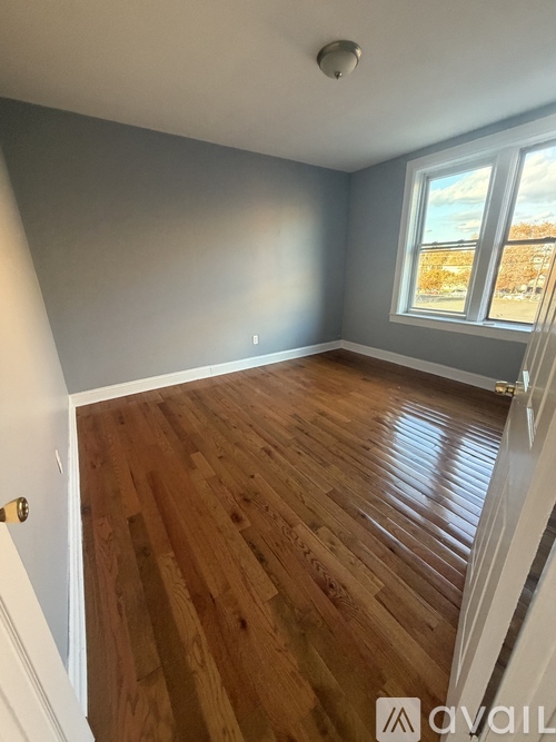 A room with wooden flooring and a window showing a snowy landscape outside.