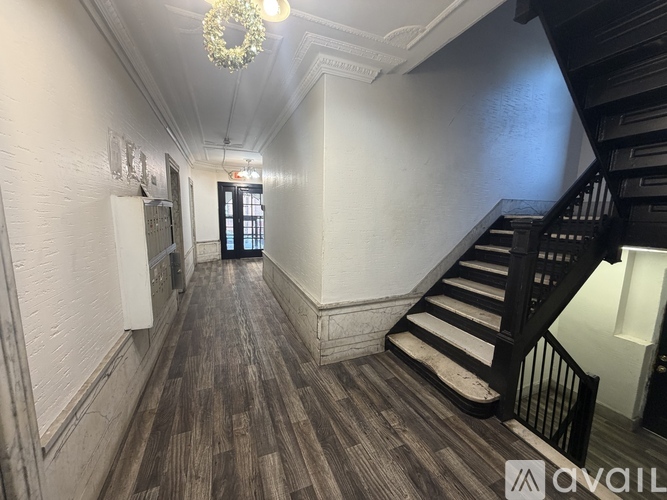 A hallway with wooden floors and a staircase.