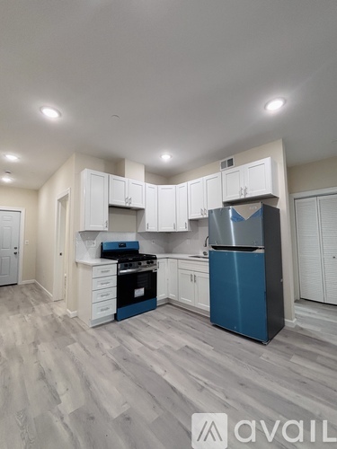 A kitchen with a blue fridge and stove top oven.