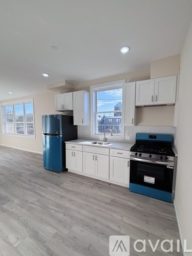A kitchen with a blue fridge and stove top oven.