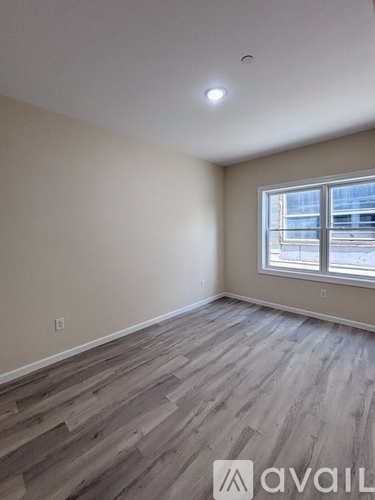 A room with wooden flooring and a window.