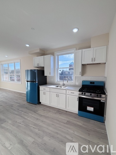 A kitchen with a blue fridge and stove top oven.