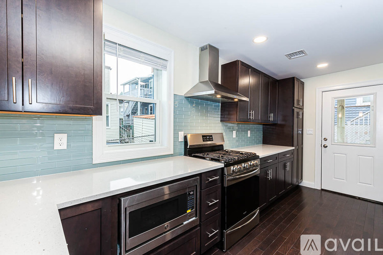 A kitchen with dark brown cabinets and a white countertop.