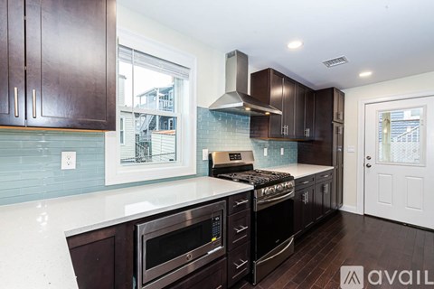 A kitchen with dark brown cabinets and a white countertop.