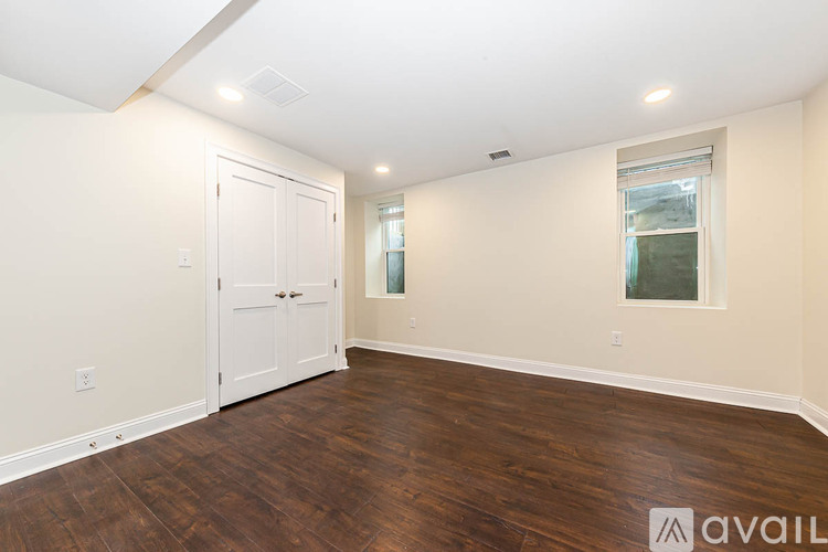A room with a white door and a window with a view of a building outside.