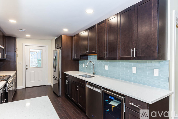 A kitchen with dark brown cabinets and a white counter top.