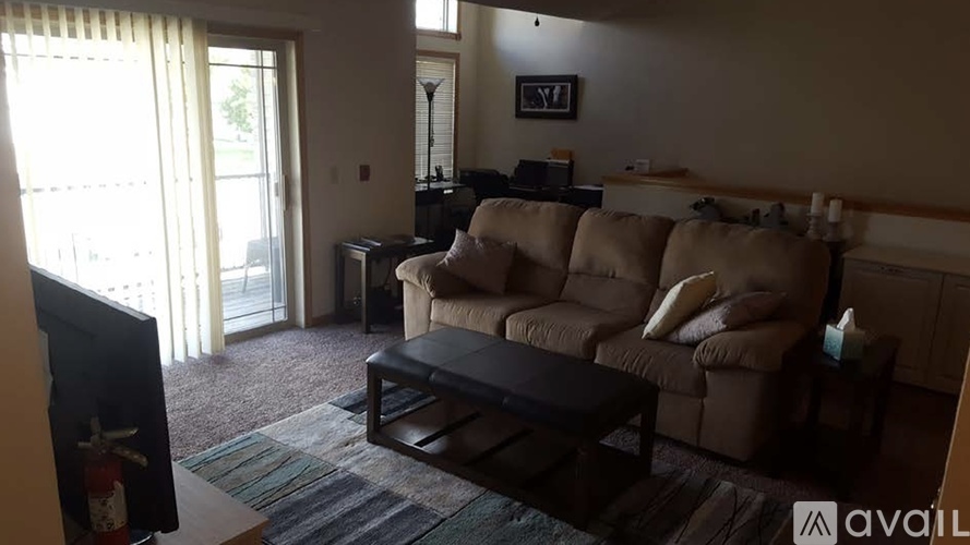 A living room with a couch, chair, and television.