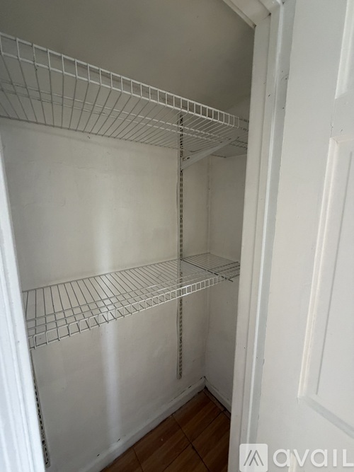 Empty wire shelving in a white closet.