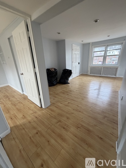 A room with wooden flooring and white walls.