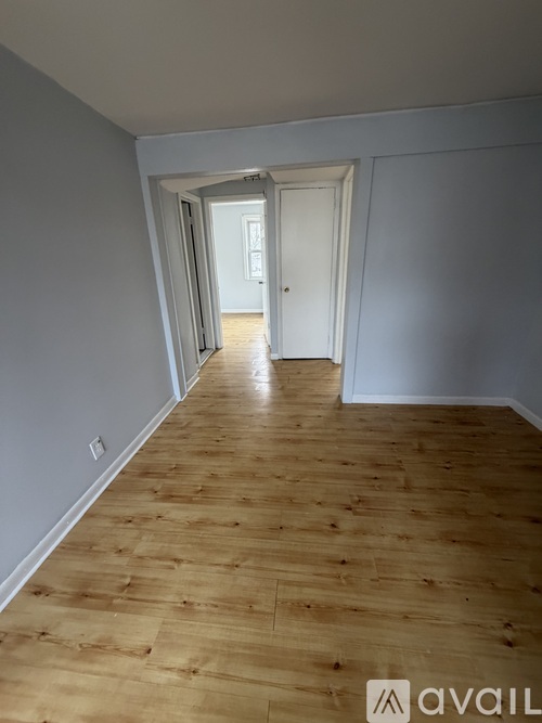 A long hallway with wooden floors and white walls.