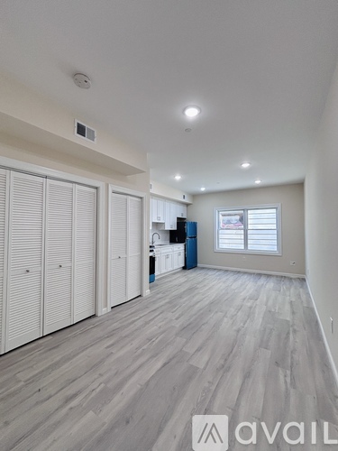 A room with a long wooden floor and white walls.