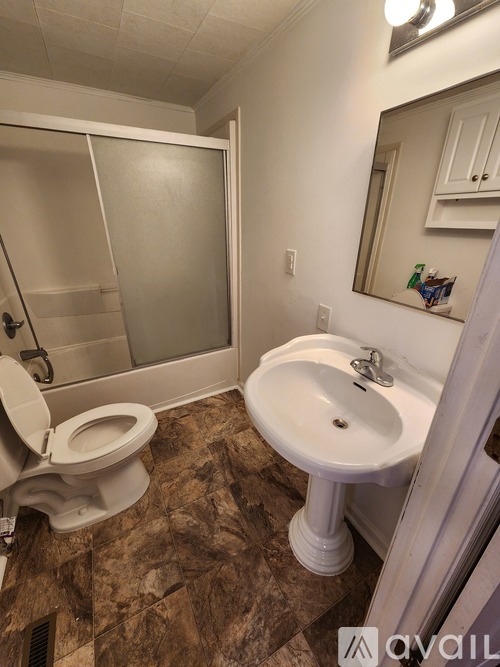 A bathroom with a toilet, sink, and shower.