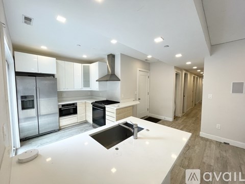 A modern kitchen with stainless steel appliances and white countertops.