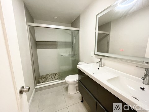 A bathroom with a toilet, sink, and shower.