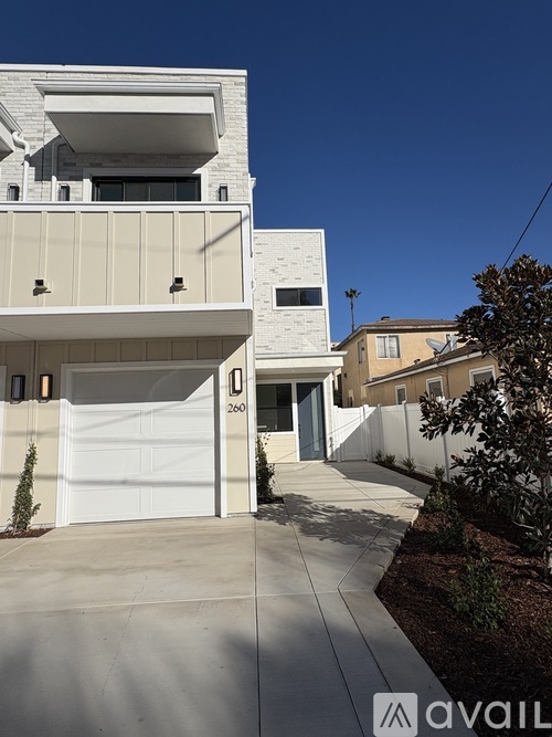 A modern house with a white garage door and a driveway.