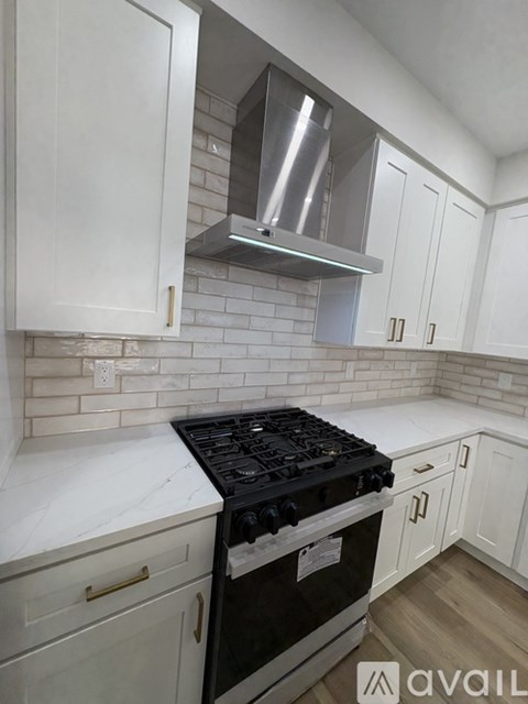 A kitchen with white cabinets and a black stove top.